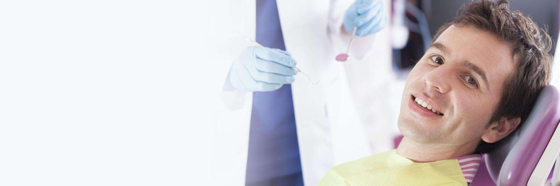 A smiling man getting a dental exam | dentist Brandon, FL