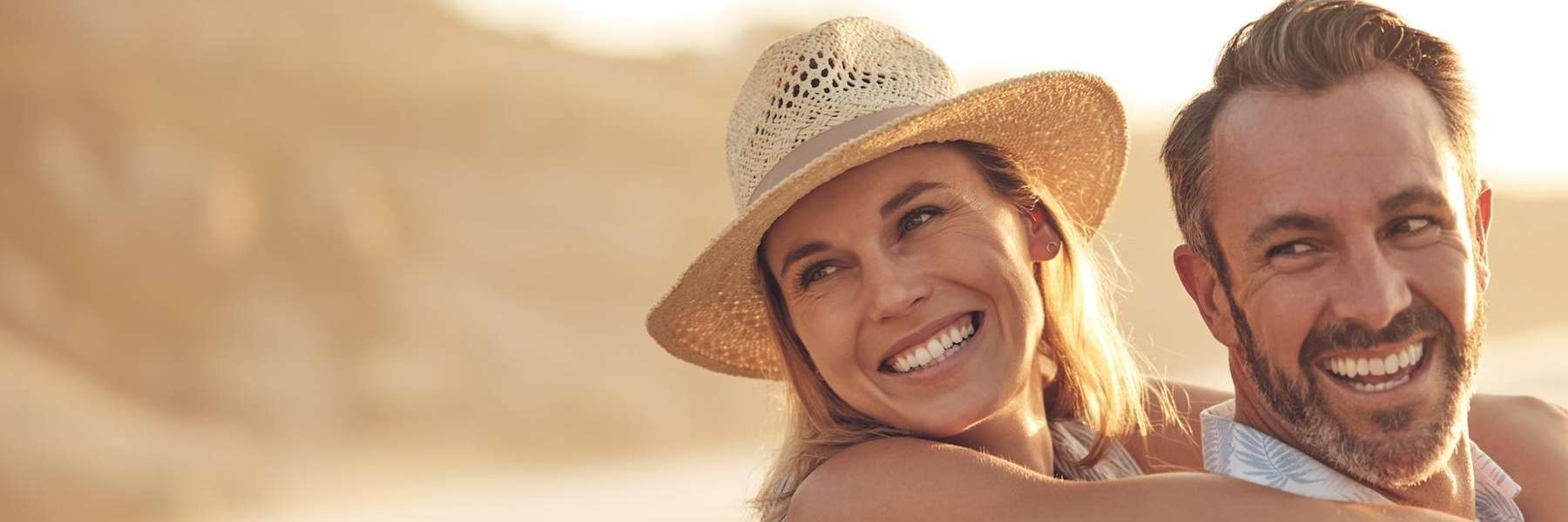 A smiling couple embraces, highlighting companionship's role in coping with stress and oral health