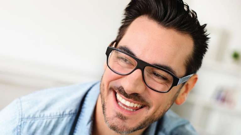 A man with glasses laughing | dental implants Brandon FL