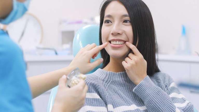 A woman showing her teeth to her dentist in Brandon, FL