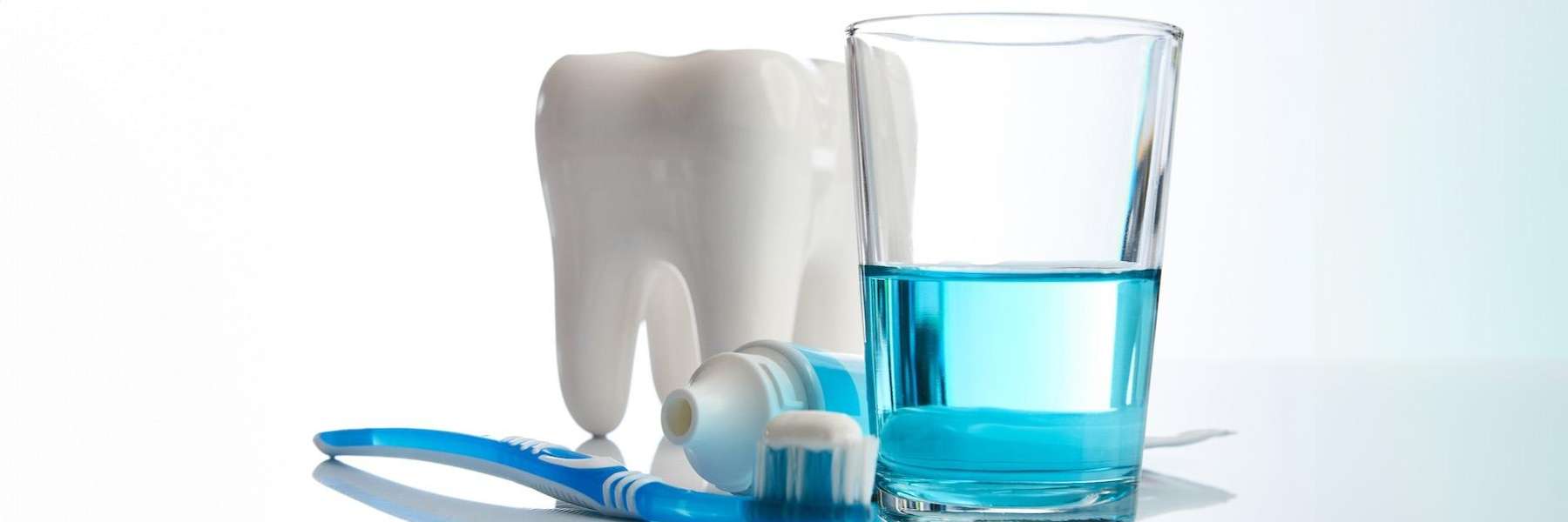 A tooth model with a toothbrush, toothpaste, and mouthwash
