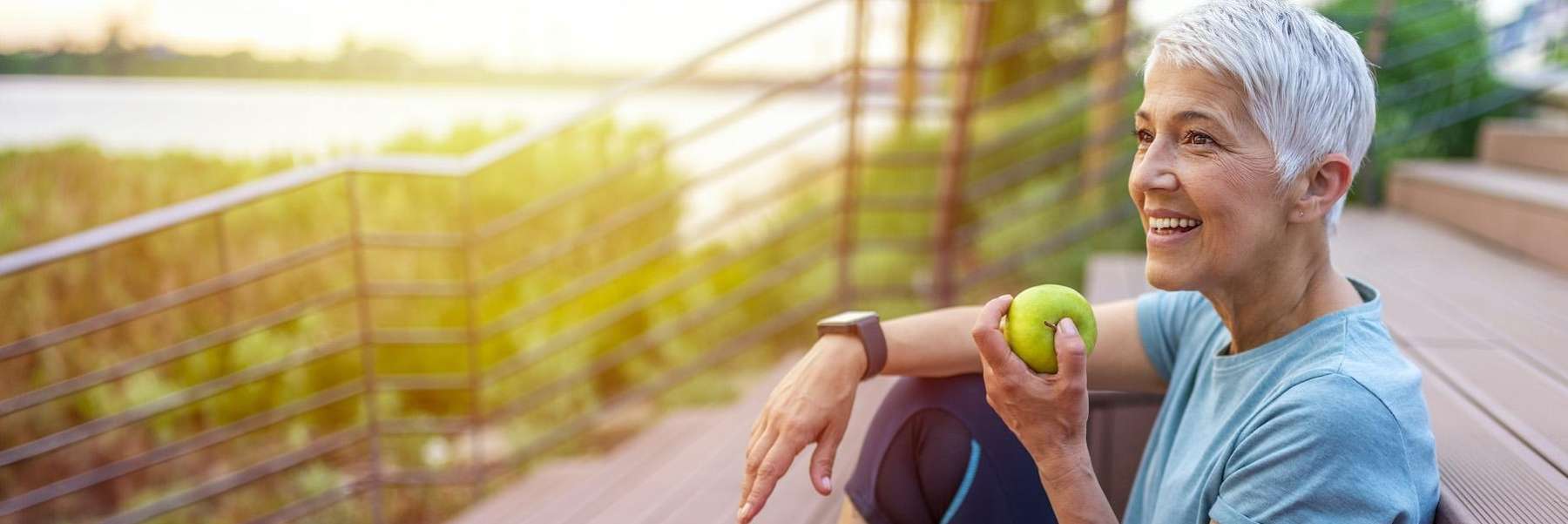 A woman eating an apple outdoors | how to practice oral hygiene